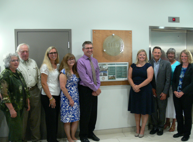 Team members from Berry Architecture and DRHF Accountants gather in front of a plaque denoting the building’s LEED Gold certification. The office in Red Deer, AB is the first 100% privately owned LEED Gold building in the province.
